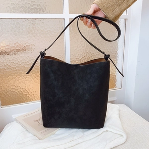 Minimalist black matte bucket bag with adjustable strap and contrasting brown interior