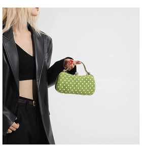 Détail du sac de soirée vert à pois avec poignée dorée et fermoir à pierre précieuse