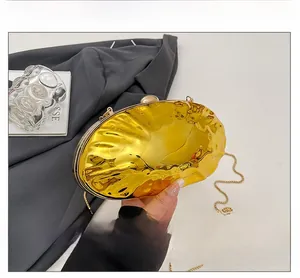 Detailed macro view of the gold shell-shaped evening clutch with mirrored metal finish