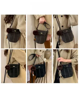 Detailed views of gray suede bucket bag with contrast stitching and decorative charms