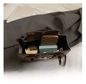 Internal capacity of crocodile pattern handbag showing space for phone and makeup