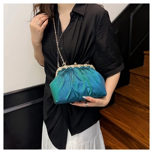 Detail of gradient blue-green clutch bag with pleated cloud design and rhinestone gold frame