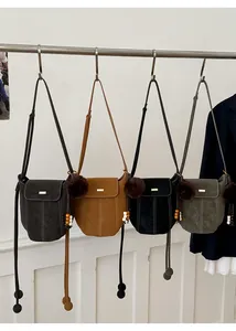 Detail view of retro bucket bags in four colors with fuzzy charms and metallic buckles