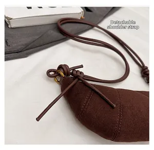 Dettaglio borsa croissant in pelle scamosciata marrone con tracolla rimovibile dorata