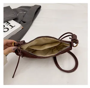 Dettaglio interno di borsa a mano marrone trapuntata con fodera beige e tasca laterale
