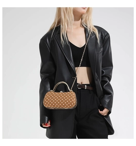 Détail du sac bandoulière à pois avec poignée dorée et fermoir brillant élégant
