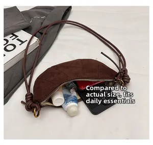 Dettaglio borsa a mezzaluna in camoscio che mostra la capienza per cellulare e oggetti