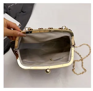 Detail view of gold metal frame chain bag with grey herringbone lining and zipper pocket