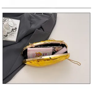 Interior view of shell-shaped gold clutch showing capacity for phone, wallet and lipstick