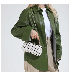Polka dot mini square bag worn with a green leather jacket and gold chain strap