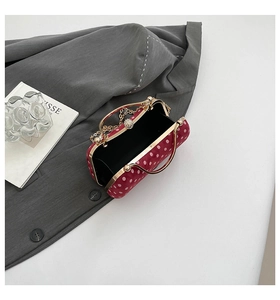 Vue détaillée de la pochette rouge à pois avec poignée dorée et fermoir perle chic