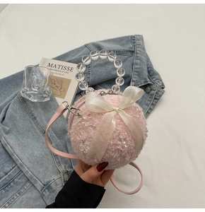 Detailed shot of pink faux fur ball bag with white silk bow and acrylic bead handle