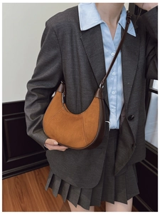 Detail view of vintage brown suede hobo bag with parallel stitching and matte strap finish