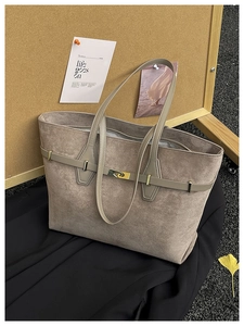 Détail du sac cabas en daim taupe avec fermoir rotatif doré et sangle décorative