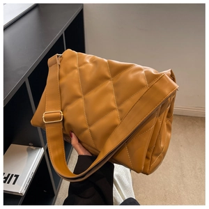 Detailed view of yellow quilted underarm bag with soft PU leather and adjustable strap