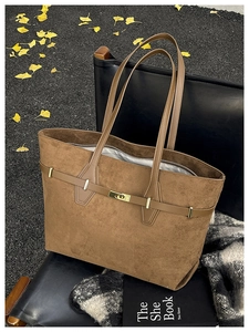 Vue détaillée du sac cabas en daim marron avec lanières en cuir et boucle dorée