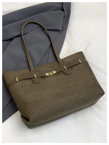 Détail d'un cabas vintage marron foncé montrant la texture suède et le fermoir doré