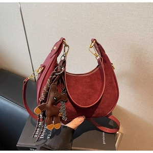 Détail du sac hobo bordeaux en cuir lisse avec un pendentif mignon en forme d'ours