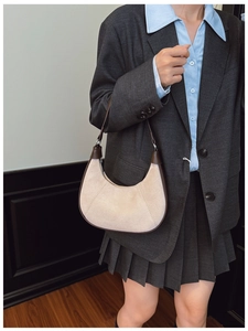 Detailed side view of vintage crossbody bag with matte suede texture and leather trim