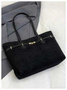 Détail d'un sac cabas noir mat avec boucle en métal doré et bandoulière en cuir