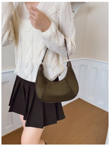 Detail of dark olive crescent shoulder bag with suede texture and contrast leather trim