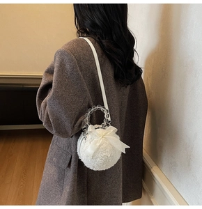 Close-up of fluffy white faux fur bag with a large bow and elegant beaded handle