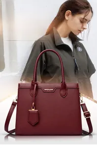 Detail of wine red lychee pattern handbag with gold hardware and removable strap