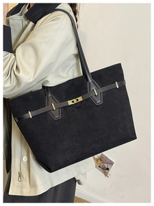 Détail d'un grand sac cabas noir vintage en suède avec fermeture à boucle dorée chic