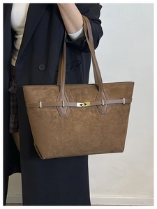 Détails du sac fourre-tout en daim marron avec boucle en métal doré et bandoulière en cuir