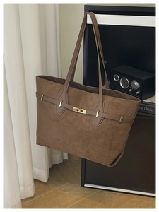 Détail du sac cabas en daim marron avec boucle dorée et fines bandoulières en cuir souple