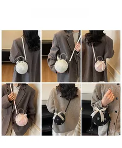 Detail of plush spherical faux fur bag with transparent beaded handle and silk bow accents