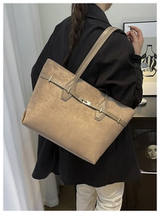 Détail d'un grand sac cabas en daim kaki avec boucle métallique et bandoulière chic