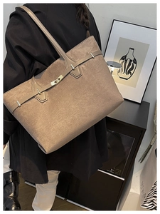Détail d'un sac cabas en daim avec sangle contrastée et fermoir doré en studio moderne