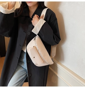Close-up of minimalist cream white pebbled leather waist bag with a metal snap pocket