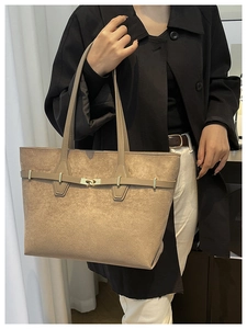 Gros plan du sac cabas kaki avec fermoir pivotant en métal et texture daim élégante
