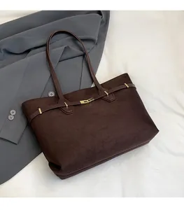 Détail du grand sac cabas en daim marron foncé avec boucle dorée et lanière