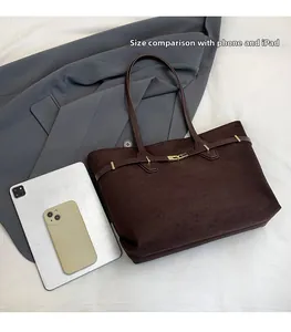 Détail montrant la capacité du cabas vintage par rapport à un smartphone et une tablette