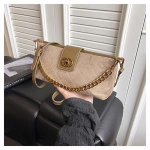 Detail of khaki suede shoulder bag with quilted pattern and gold chain strap decoration