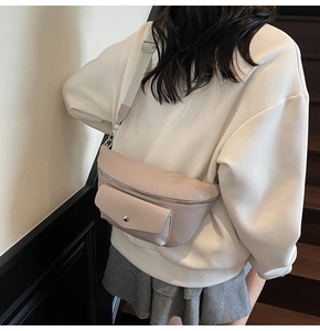 Close-up of beige lychee leather crossbody bag featuring metal zipper and wide webbing strap