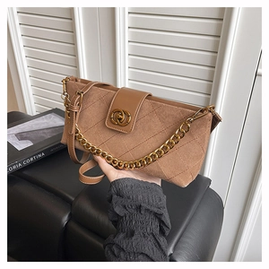 Detail of brown quilted suede crossbody bag with gold chain strap and metal lock