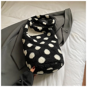 Détail du sac seau en peluche avec motif à pois noirs et blancs sur tissu doux