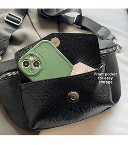 Detail of black pebbled leather waist bag showing front pocket storage with magnetic buckle