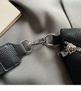 Close-up of black lychee grain leather texture with premium silver metal hardware