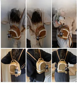 Detail of plush mini backpacks in brown and beige with faux fur trim and rabbit charm
