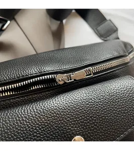 Macro shot of silver metal zipper and black lychee grain leather on crossbody bag