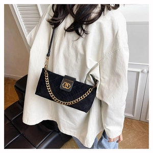 Detail of black quilted shoulder bag featuring gold chain and interlocking round buckle