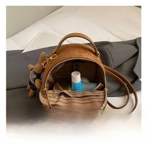 Detail view of brown faux suede backpack with plush trim and striped interior storage