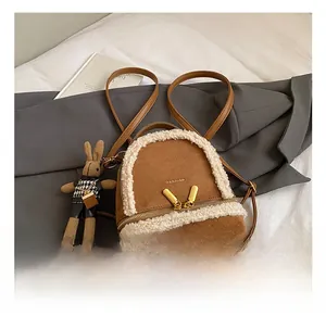 Close-up of caramel faux suede backpack with white faux fur trim and gold metal zippers