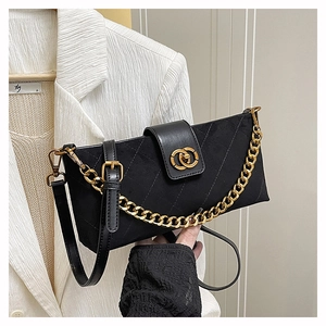 Detail of black quilted crossbody bag featuring gold chain and suede texture