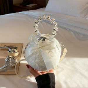Spherical white faux fur handbag with beaded handle and large satin bow decoration